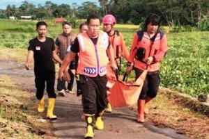 Petugas saat membawa jenazah korban anak SD yang terseret arus gorong-gorong.